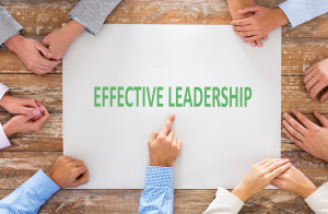 business, people and team work concept - close up of creative team sitting at table and pointing finger to blank paper in office